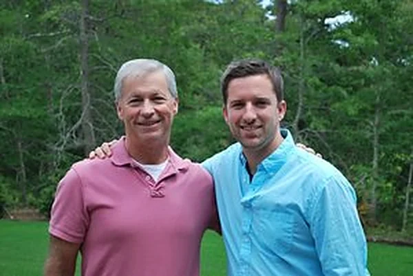 Dr. Edward Nelson and his son Dr. Andrew Nelson, standing together outdoors.